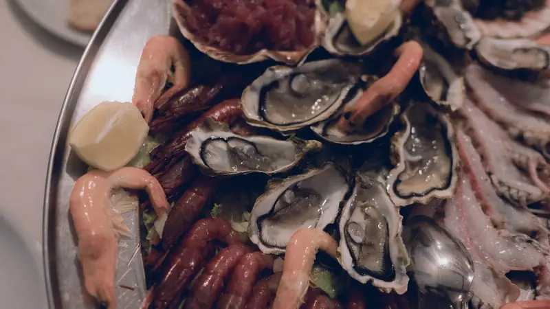 Plateau de fruits de mer avec huîtres ouvertes, crevettes et quartiers de citron
