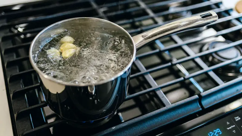 Casserole d'eau à gros bouillons sur une plaque de cuisson à gaz