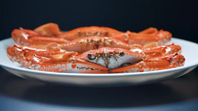 Crabes cuits à la carapace orange vif, présentés dans une assiette blanche