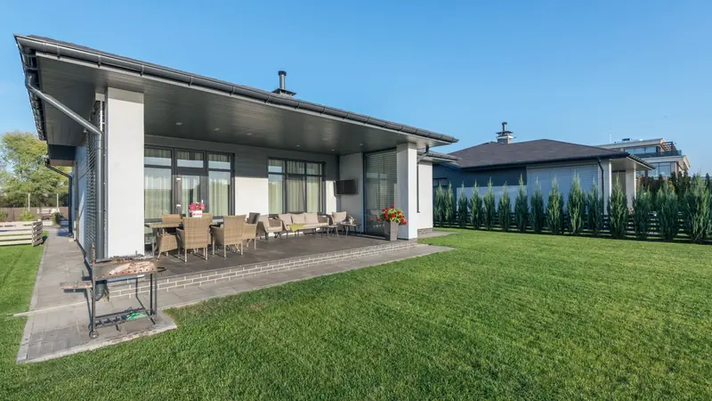 Maison de plain-pied avec terrasse couverte et grande pelouse